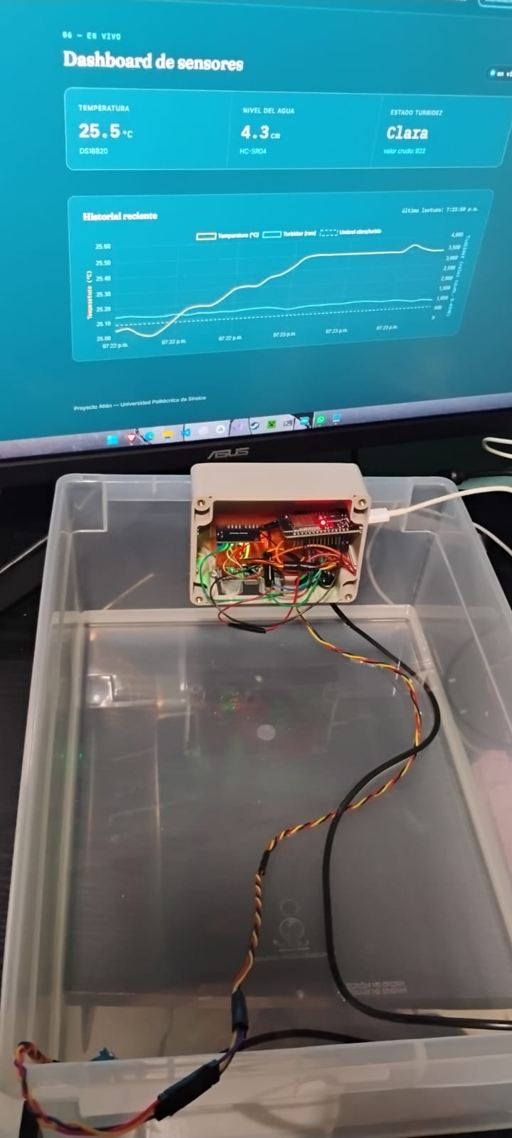 Dispositivo Atlán ya sellado y encendido, junto al dashboard mostrando las lecturas en vivo en la pantalla